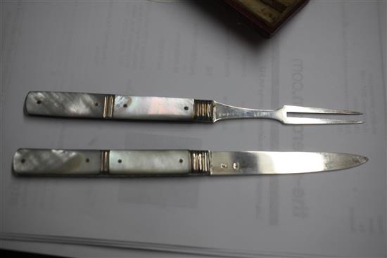 A cased Georgian silver and mother of pearl folding travelling fruit knife and fork,